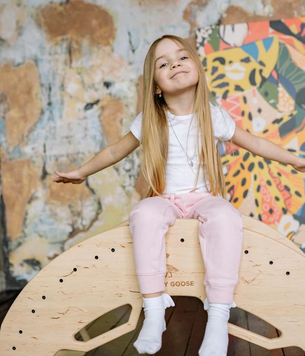 Happy child in a playful yoga pose on a colorful mat.
